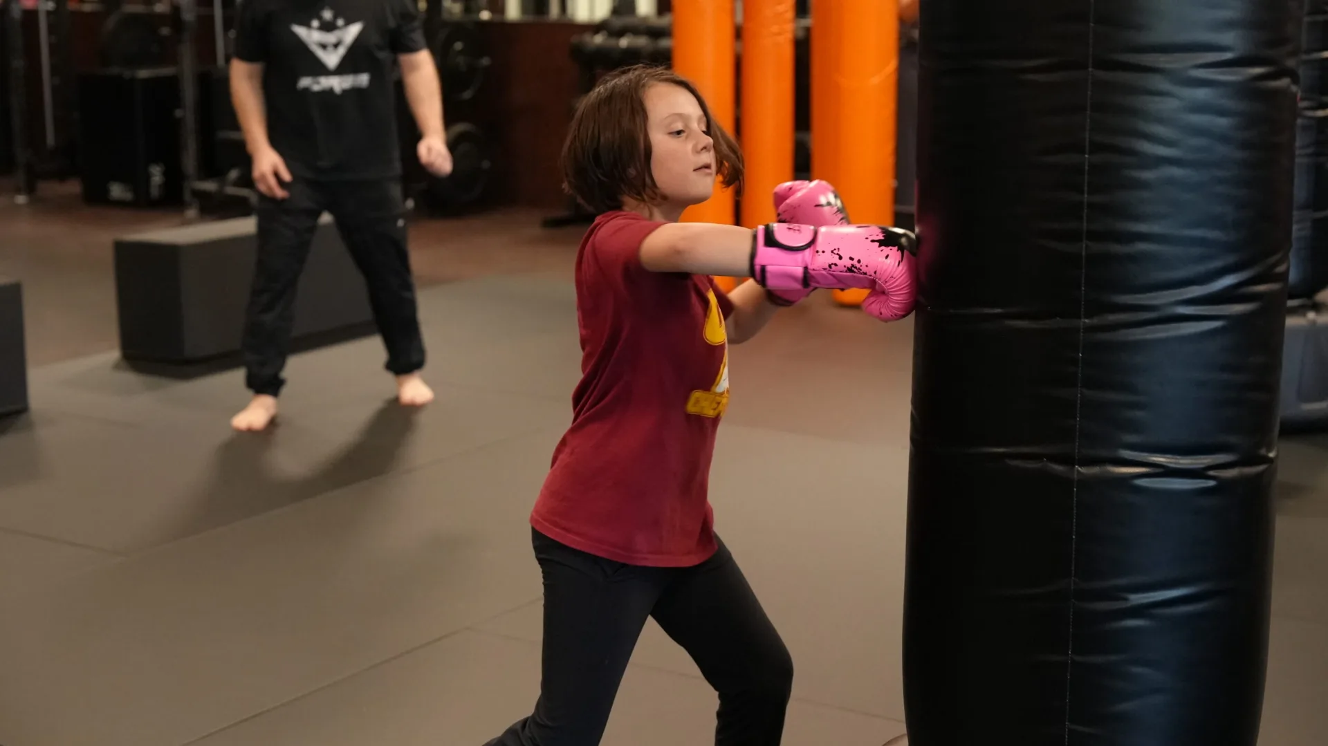 A young camper practices on a heavy bag during Forge Athletics summer camp in Naples