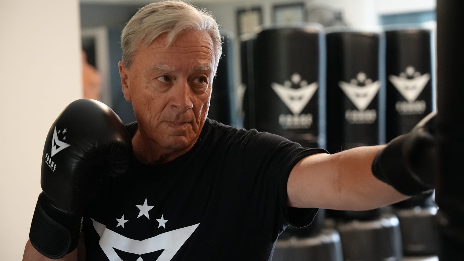 A senior member works boxing rounds at the heavy bag during personal training at Forge Athletics