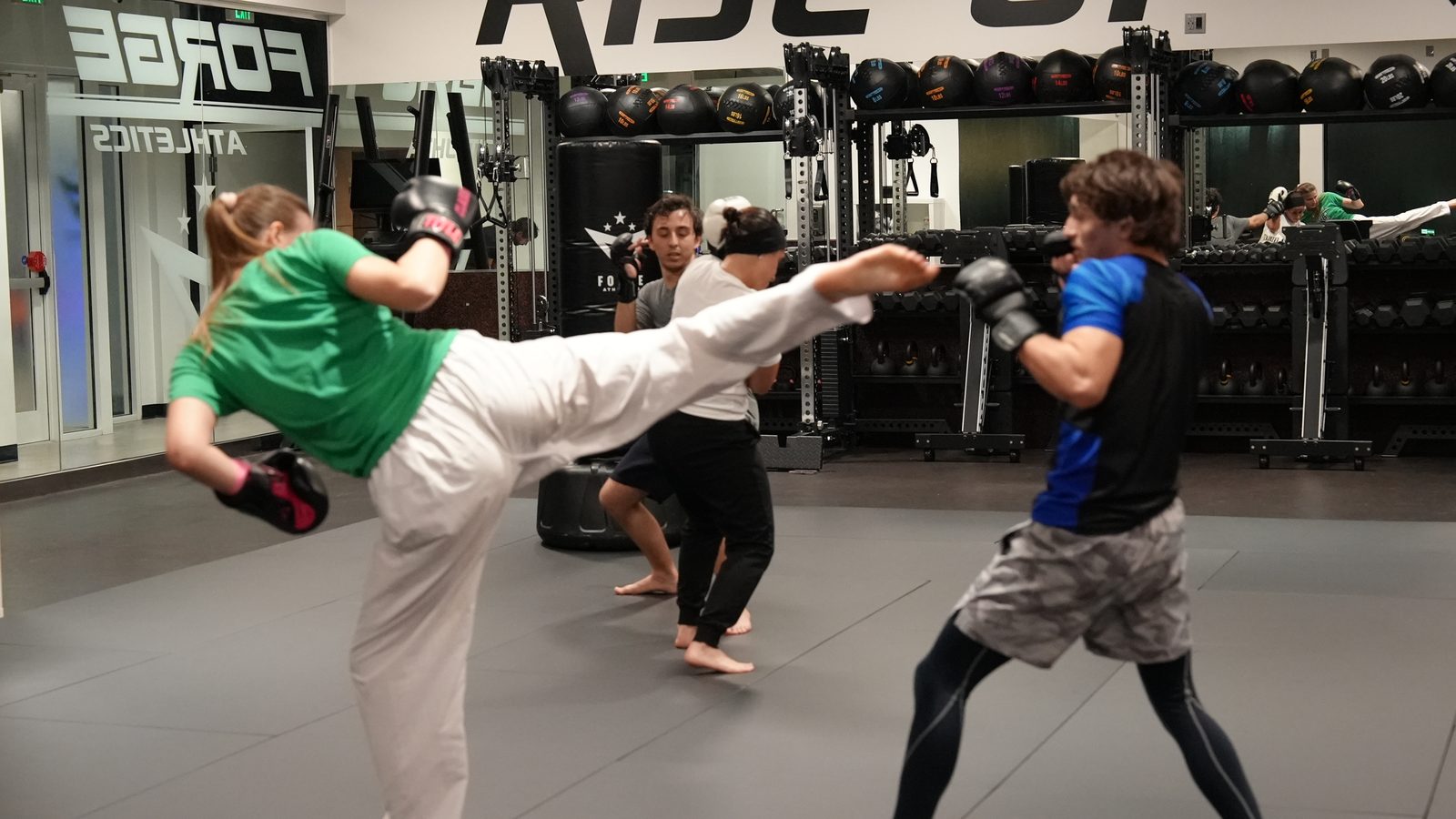 Two students trade kicks and punches during a kickboxing partner drill at Forge Athletics in Naples