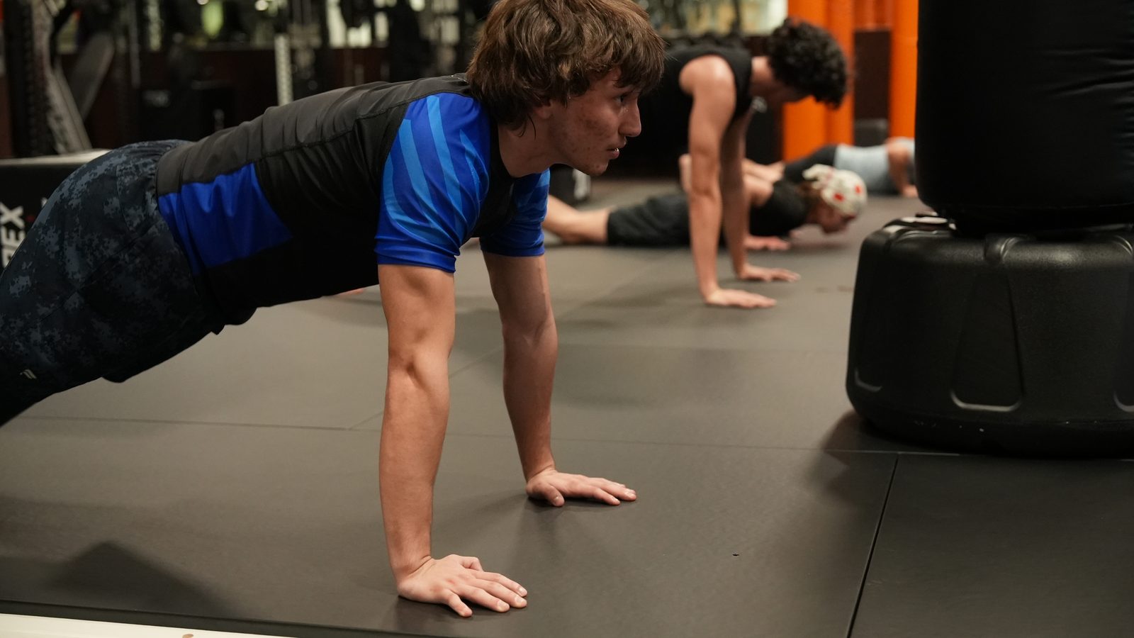Members hold a plank on the mat during a strength and conditioning class at Forge Athletics in Naples