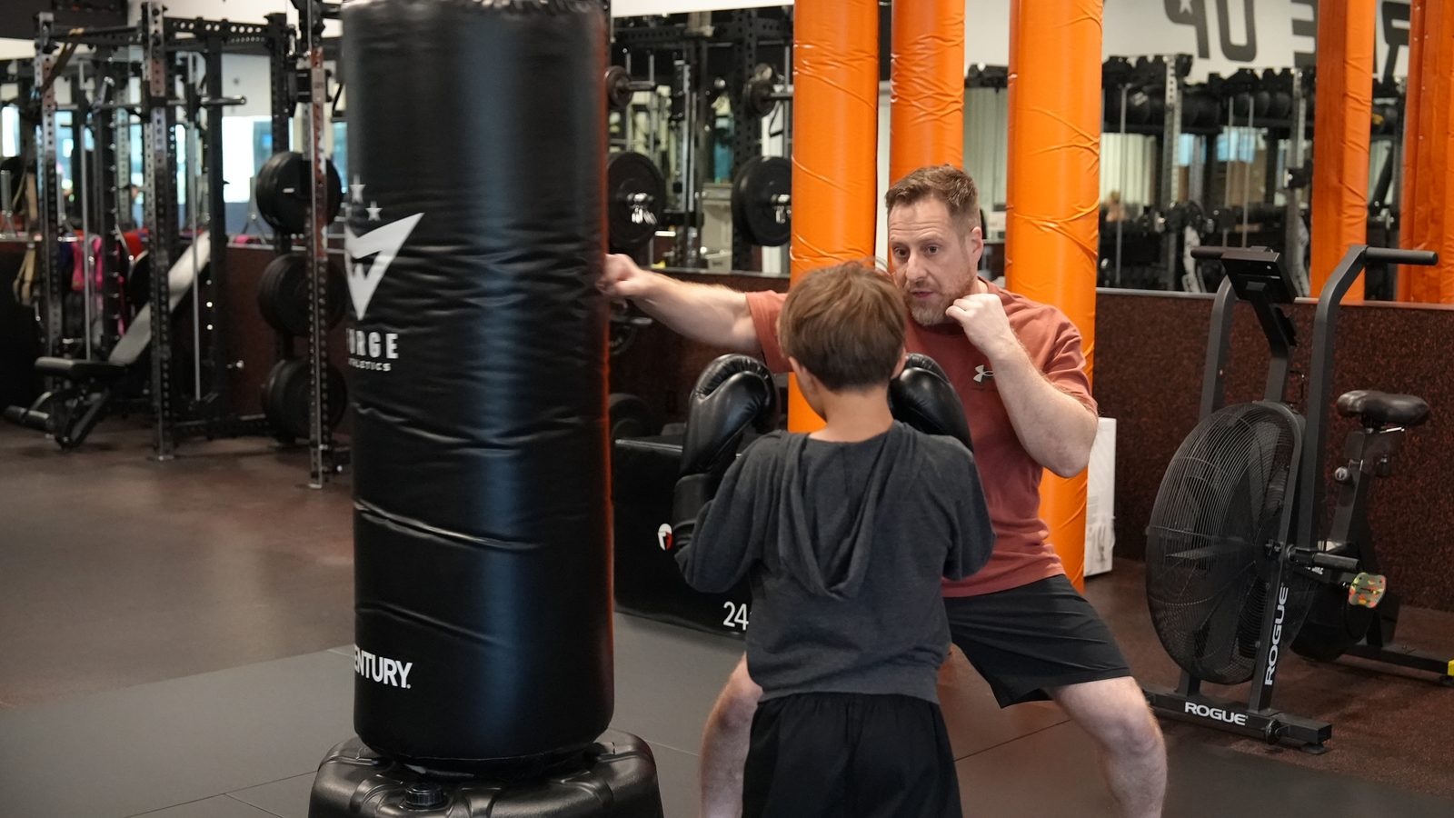 Coach Wil coaching a young student at the heavy bag