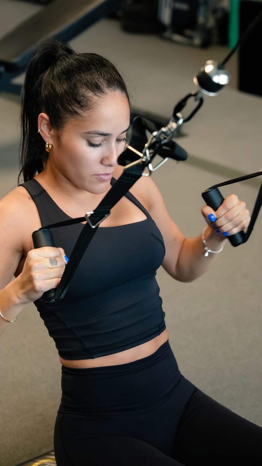 A member trains on the cable machine during a women's personal training session at Forge Athletics in Naples