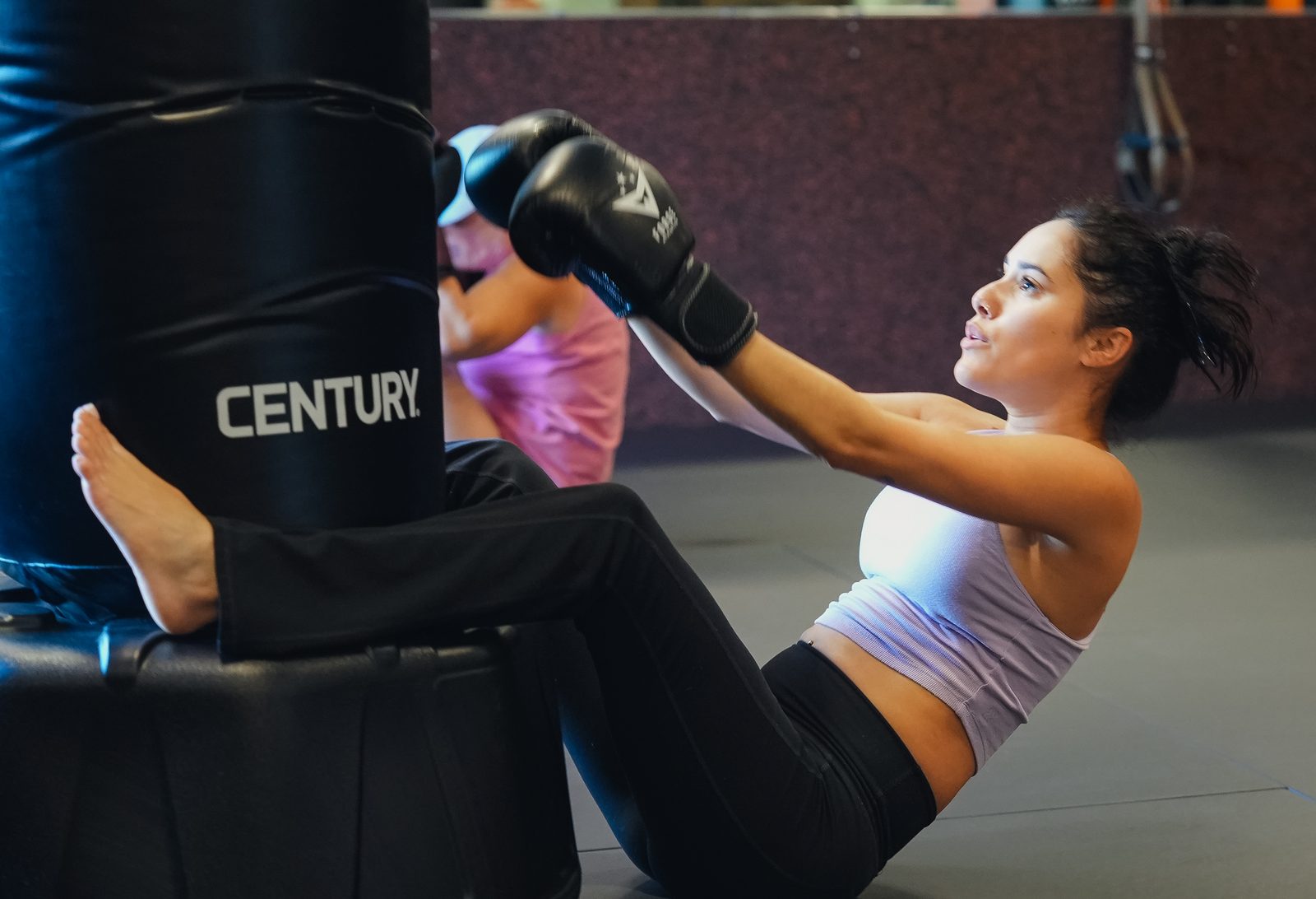 A member throws a knee strike on the heavy bag during Women's Only Kickboxing at Forge Athletics in Naples