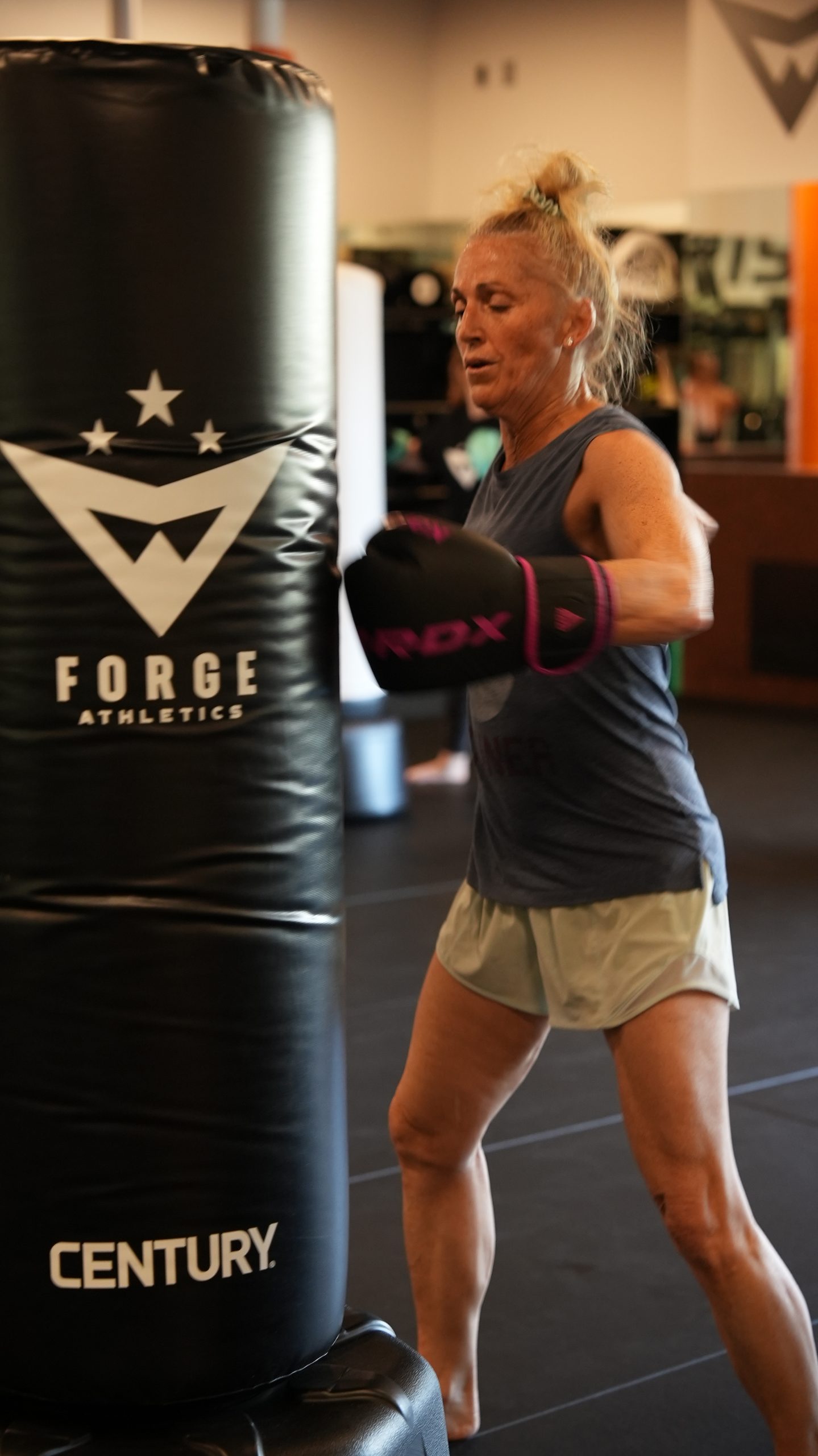 A member works combinations on the heavy bag during Women's Kickboxing at Forge Athletics in Naples