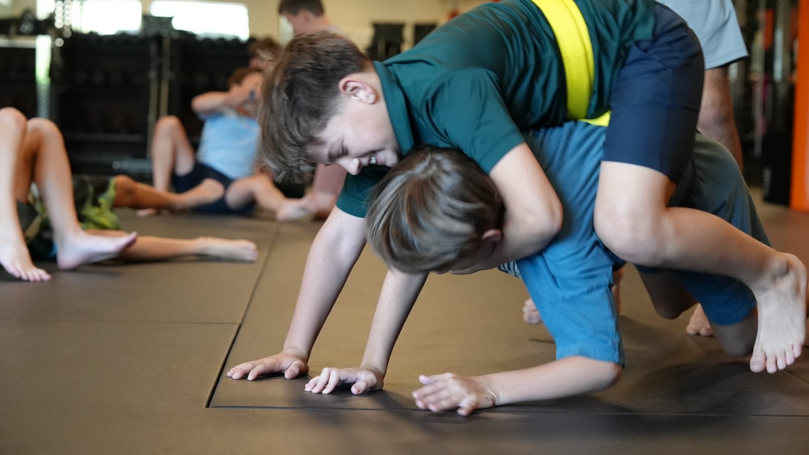 Two youth students work a takedown drill in Teen and Youth MMA class at Forge Athletics