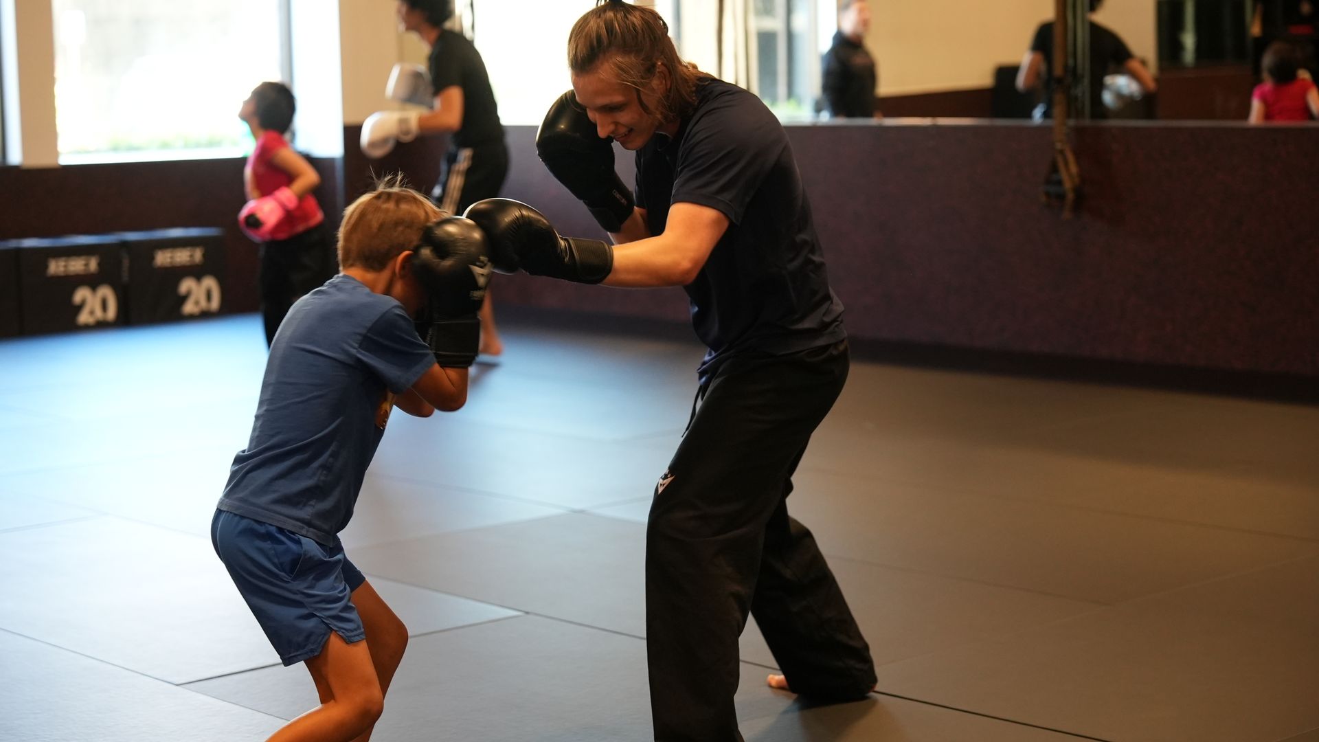 A Forge coach works a one-on-one glove drill with a young student in Naples