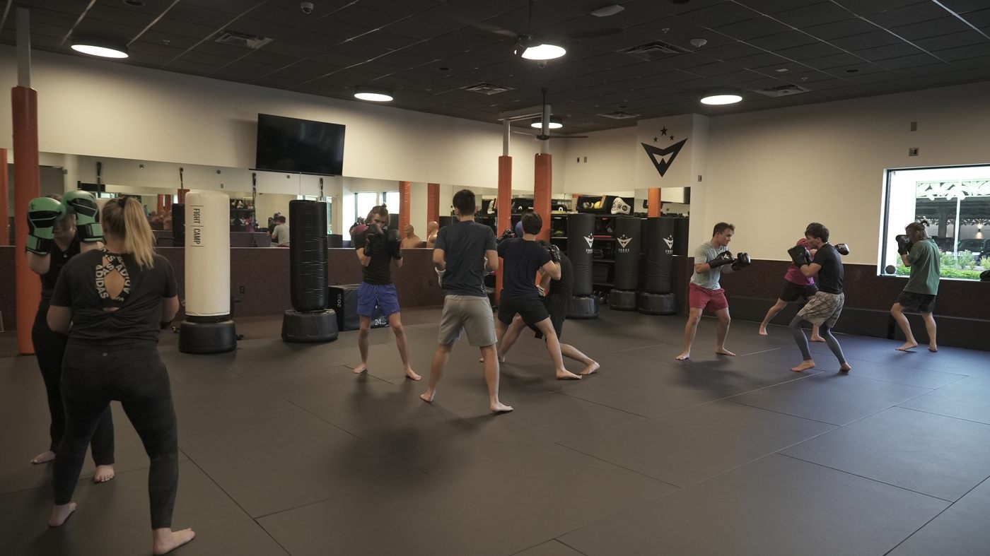 Adults work striking rounds together during a Co-Ed Kickboxing class at Forge Athletics in Naples