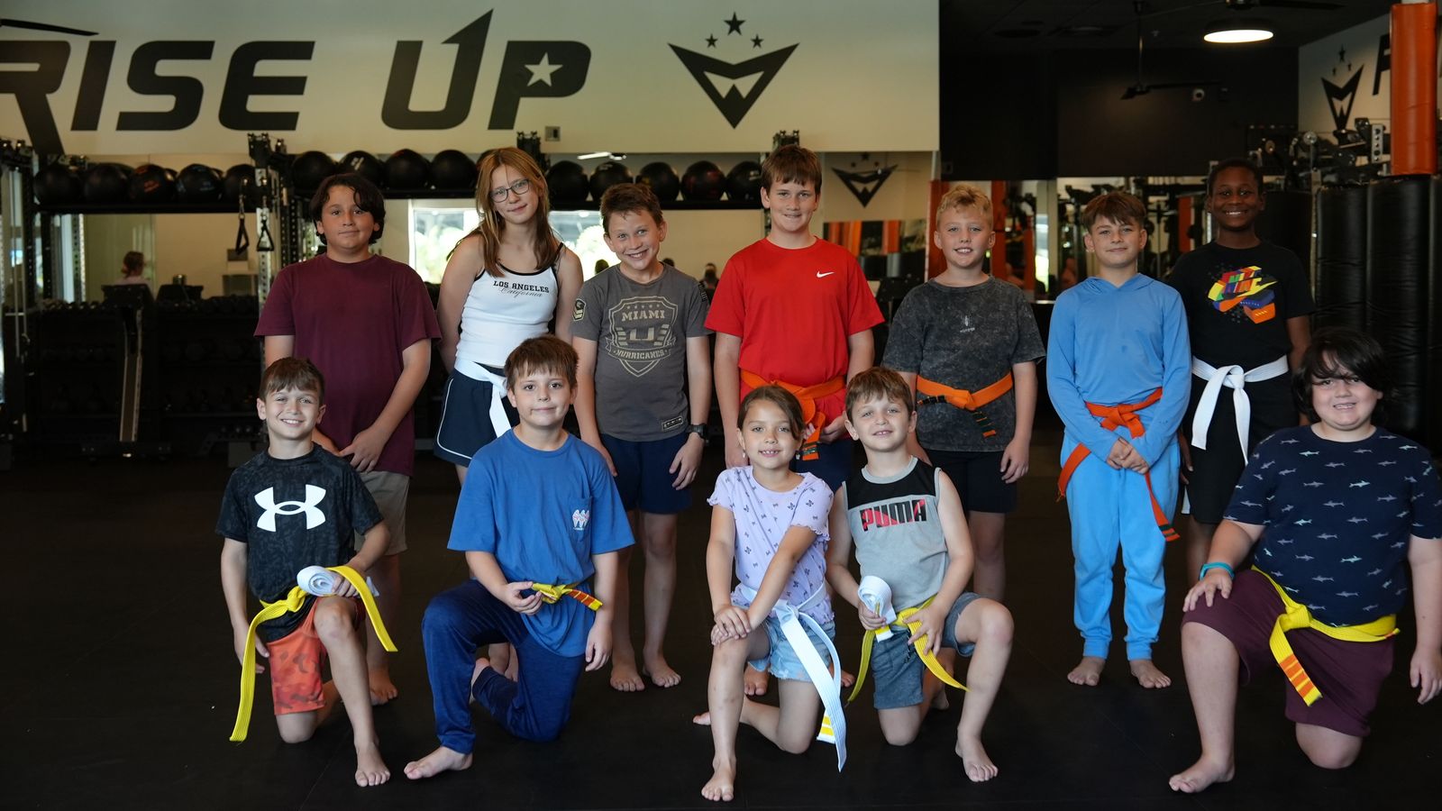 Young students line up in their belts at the start of kids martial arts class at Forge Athletics
