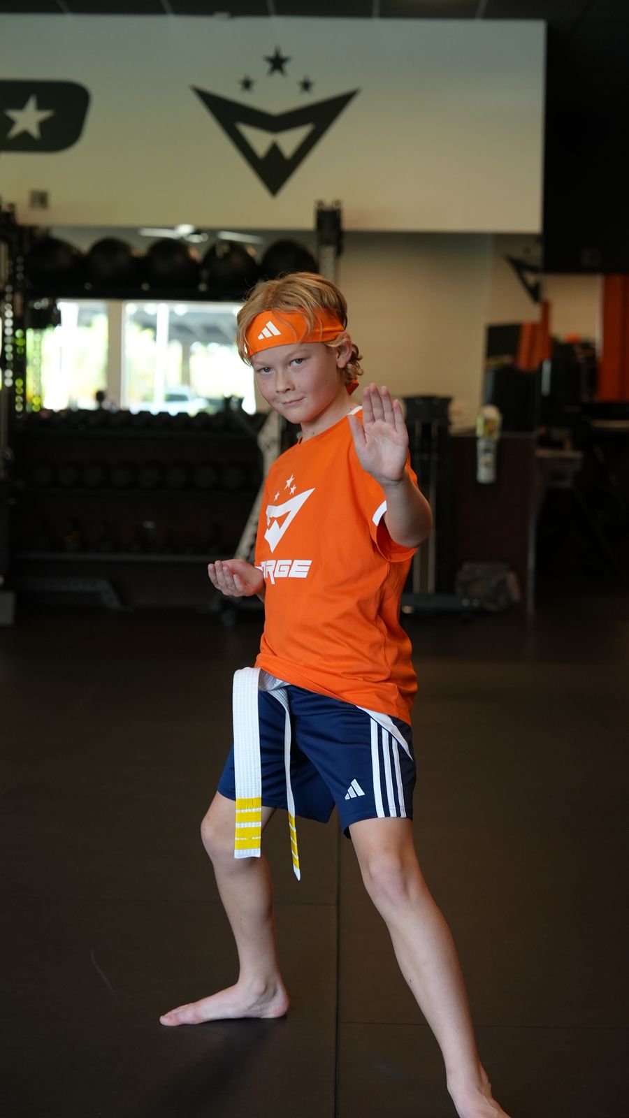A young student holds his fighting stance during kids martial arts class at Forge Athletics