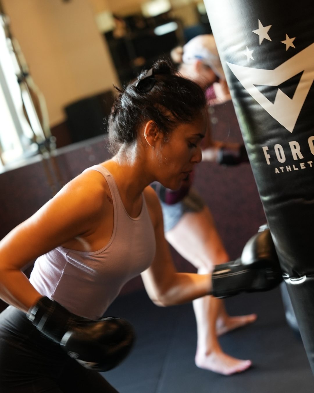 A member fires a punch into the heavy bag during a women's self-defense drill at Forge Athletics in Naples