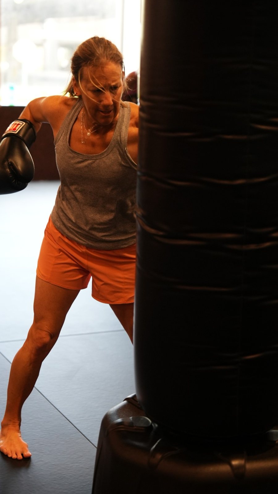 A member drives a punch into the heavy bag during a women's class at Forge Athletics in Naples