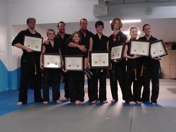 Wil Pino embraces a student receiving a new black belt at Elite Martial Arts