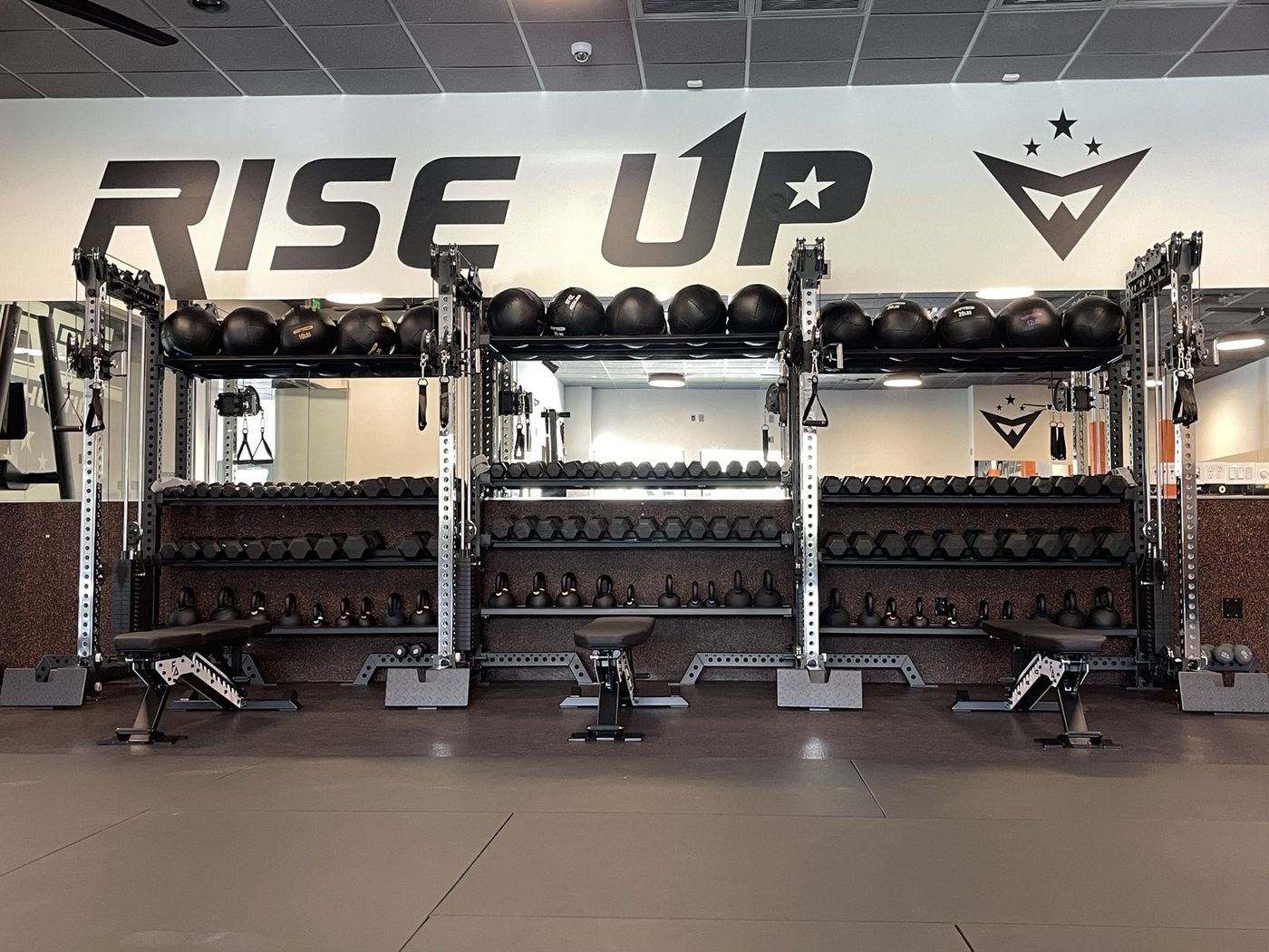 The RISE UP wall over the dumbbell racks and benches inside the new Forge Athletics gym
