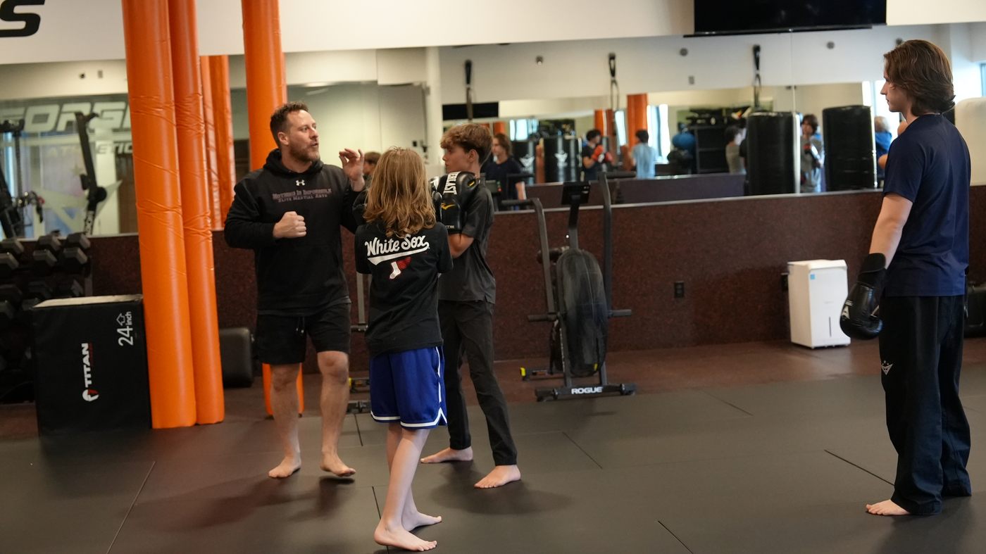 Coach Wil teaches a kids class on the mats of the new Forge Athletics gym